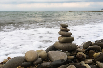 Fototapeta na wymiar Balancing pyramid of sea stones on a pebble beach