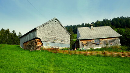 Obraz premium romantische Bauerngehöft am Schweizer Amdener Höhenweg auf grüner Wiese unter blauem Himmel