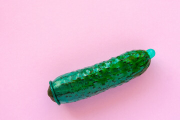vegetable penis shape and latex condom on it - contraception background