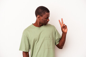 Young African American man isolated on white background joyful and carefree showing a peace symbol with fingers.