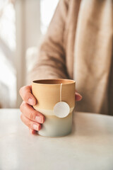 Woman's hand holding a tea cup in tea shop