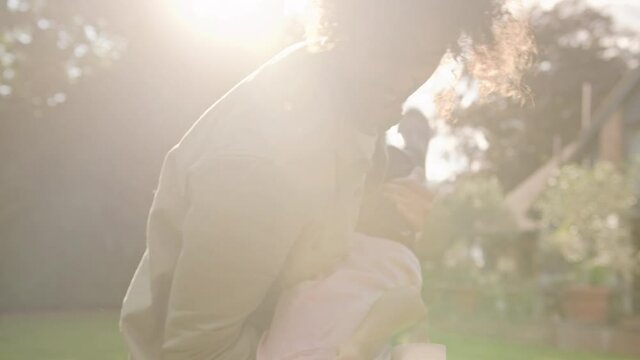 Slow motion of father holding son upsidedown in garden