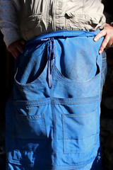 hand detail of worker wearing denim apron