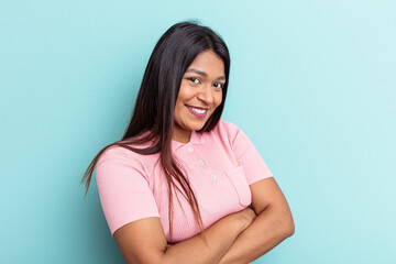 Obraz premium Young Venezuelan woman isolated on blue background who feels confident, crossing arms with determination.