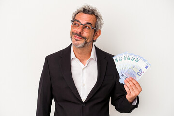 Middle age business man holding bills isolated on blue background  dreaming of achieving goals and purposes