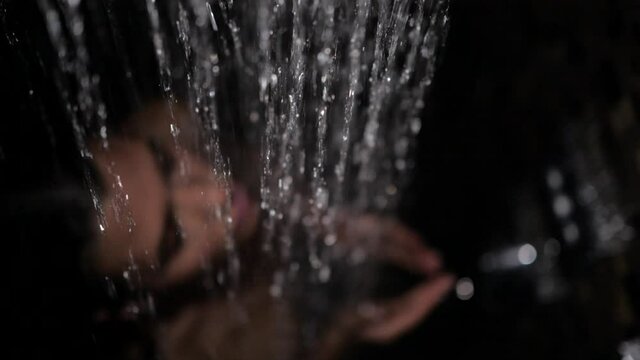 attractive brunette girl washes standing under the shower, strokes her body with her hands. High quality FullHD footage