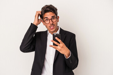 Young mixed race business man holding mobile phone isolated on white background being shocked, she has remembered important meeting.