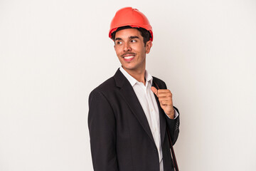 Young architect mixed race man isolated on white background looks aside smiling, cheerful and pleasant.