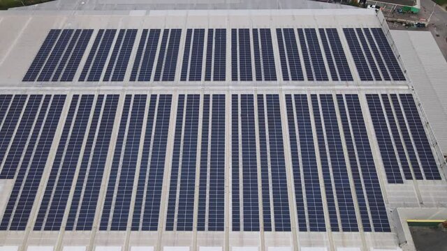 Aerial drone image of solar panels installed on a roof of a large industrial building or a warehouse. Industrial buildings.The renevable energy sustainable sources green power photovoltaic.
