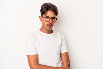 Young mixed race man isolated on white background frowning face in displeasure, keeps arms folded.