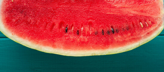 Watermelon sliced in a half on the wooden turquoise background. Red juicy summer fruit berry