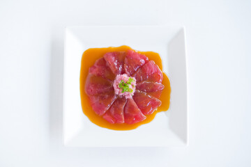 Tuna sashimi with sauce on white plate on white background. Isolated on white. Japanese restaurant. Japanese traditional food. Photo for menu