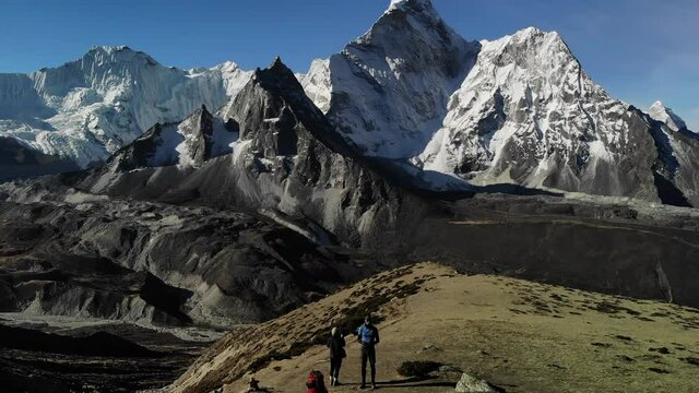 Nepal, Everest Region. Three passes trek. Khongma La pass from Chukung. Drone video moving up & backwards with Ama Dablam in the background, two hikers, woman and male in foreground.