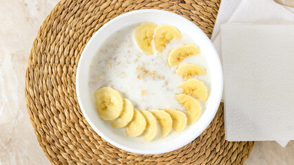 Healthy oatmeal porridge in a plate with bananas. A healthy and hearty breakfast.