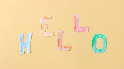 Colored letters made of paper are formed into the word HELLO. The concept of greeting.