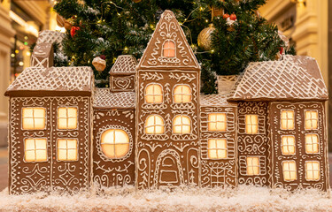 artificial ginger bread house with lights on. Christmas and new year holidays interior decoration.