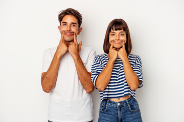 Young mixed race couple isolated on white background doubting between two options.