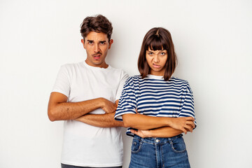 Fototapeta premium Young mixed race couple isolated on white background unhappy looking in camera with sarcastic expression.