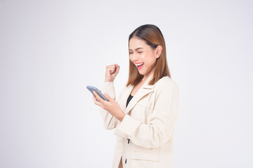Portrait of young beautiful woman in suit using smart phone over white background.