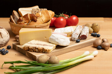 Tisch mit Holz und Käse Holzplatte, mit frischem Brot, Tomaten und Kartoffeln. Traditionelle...