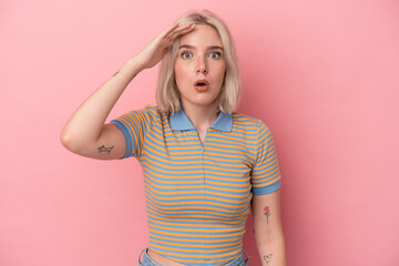 Young caucasian woman isolated on pink background shouts loud, keeps eyes opened and hands tense.