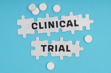 On a blue background pills and puzzles with the inscription - CLINICAL TRIAL