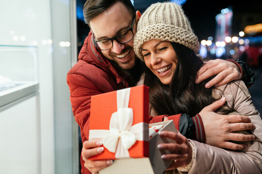 Young Couple In Love Is Celebrating With Gift. Christmas Birthday Valentines Day Present Concept