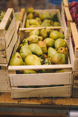 sweet ripe pears in wooden box. Seasonal fruit department in supermarket, food store. Shop local, farm products, vegan, vegetarian food