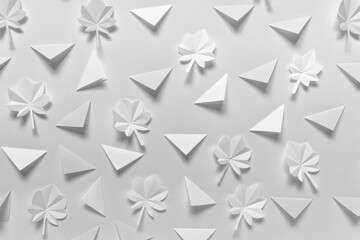 Obraz premium Simple background with folded origami triangles and white maple leaves in gray white color