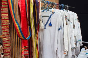 Garage sale in town hall, Tlum and Kram. Ukrainian clothes - traditional embroidered shirts. Secondhand goods on flea market, thrift shopping concept. Selective focus