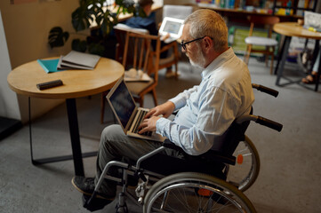 Adult disabled man using laptop, top view