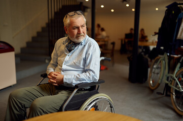 Fototapeta na wymiar Adult disabled man in wheelchair, cafeteria