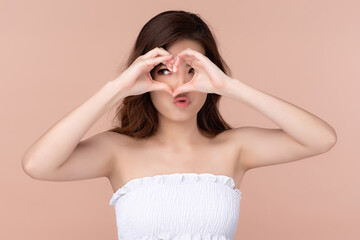 Fototapeta premium Beautiful asian woman long hair smile with clean and fresh skin happiness and cheerful with hands giving heart signal, Facial treatment, Beauty and cosmetics concept.