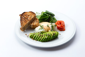 Poached egg, avocado and toast in a plate. Isolated on white.