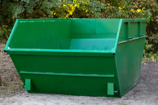 empty large green metal container for construction or other bulky garbage