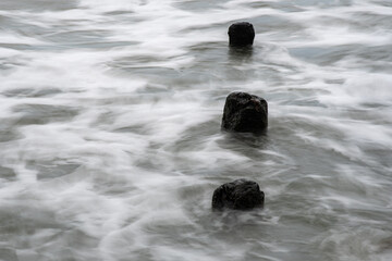 Fototapeta na wymiar Holzgebilde von Wasser umspült am Strand