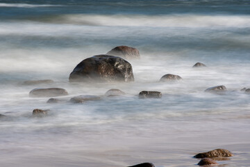 Steingebilde von Wasser umspült am Strand