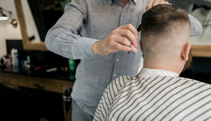 Fototapeta premium Hairdresser cutting hair of man.