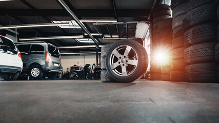 tire at repairing service garage background. Technician man replacing winter and summer tyre for...
