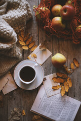 Naklejka na ściany i meble A cup of coffee on a wooden background, apples in a bag are on the table.