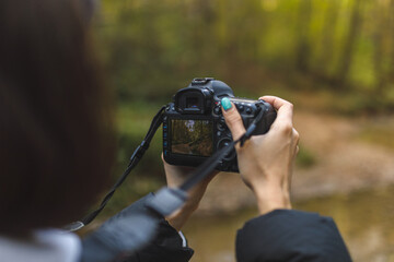 female photographer making landscape photo in autumn forest, close up detail