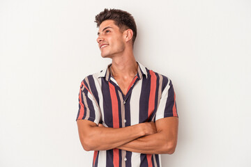 Young caucasian man isolated on white background dreaming of achieving goals and purposes