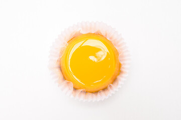 Quindim doce tradicional na culinária brasileira, feito com gemas de ovos, açúcar e coco ralado. Sobre um fundo branco.