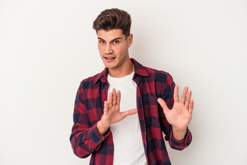 Young caucasian man isolated on white background rejecting someone showing a gesture of disgust.