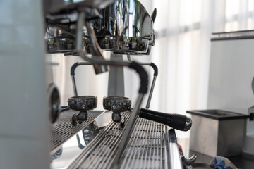 Close-up of espresso pouring from coffee machine. coffee extraction from professional coffee machine with bottomless filter and steam, barista preparing coffee at cafe