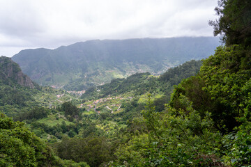 Naklejka premium Aerial view on small city Sao Vicente - Chapel on the hill, huge mountains on background. Madeira island, Portugal.