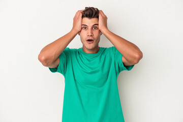 Young caucasian man isolated on white background being shocked, she has remembered important meeting.