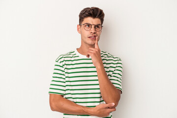 Young caucasian man isolated on white background looking sideways with doubtful and skeptical expression.