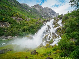 Fototapeta na wymiar Kleivafossen waterfalls and mountains near briksdalsbreen Glacier in Norway.