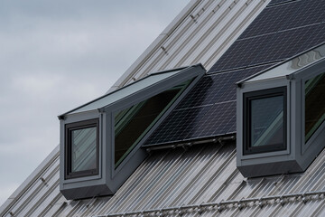 metallic windows on a top flor with a metallic sloping roof 